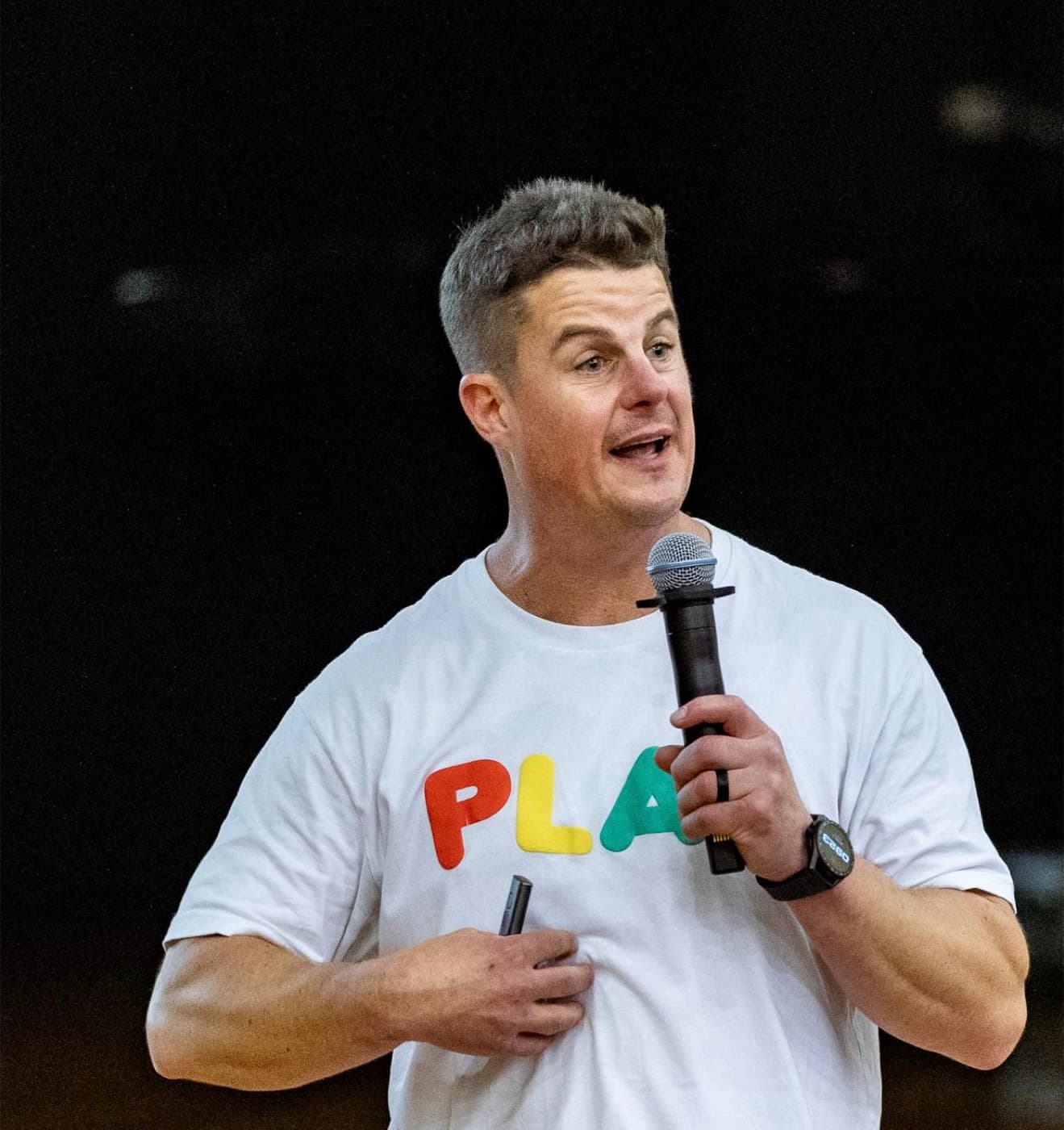 Dale Sidebottom speaking on stage with a microphone