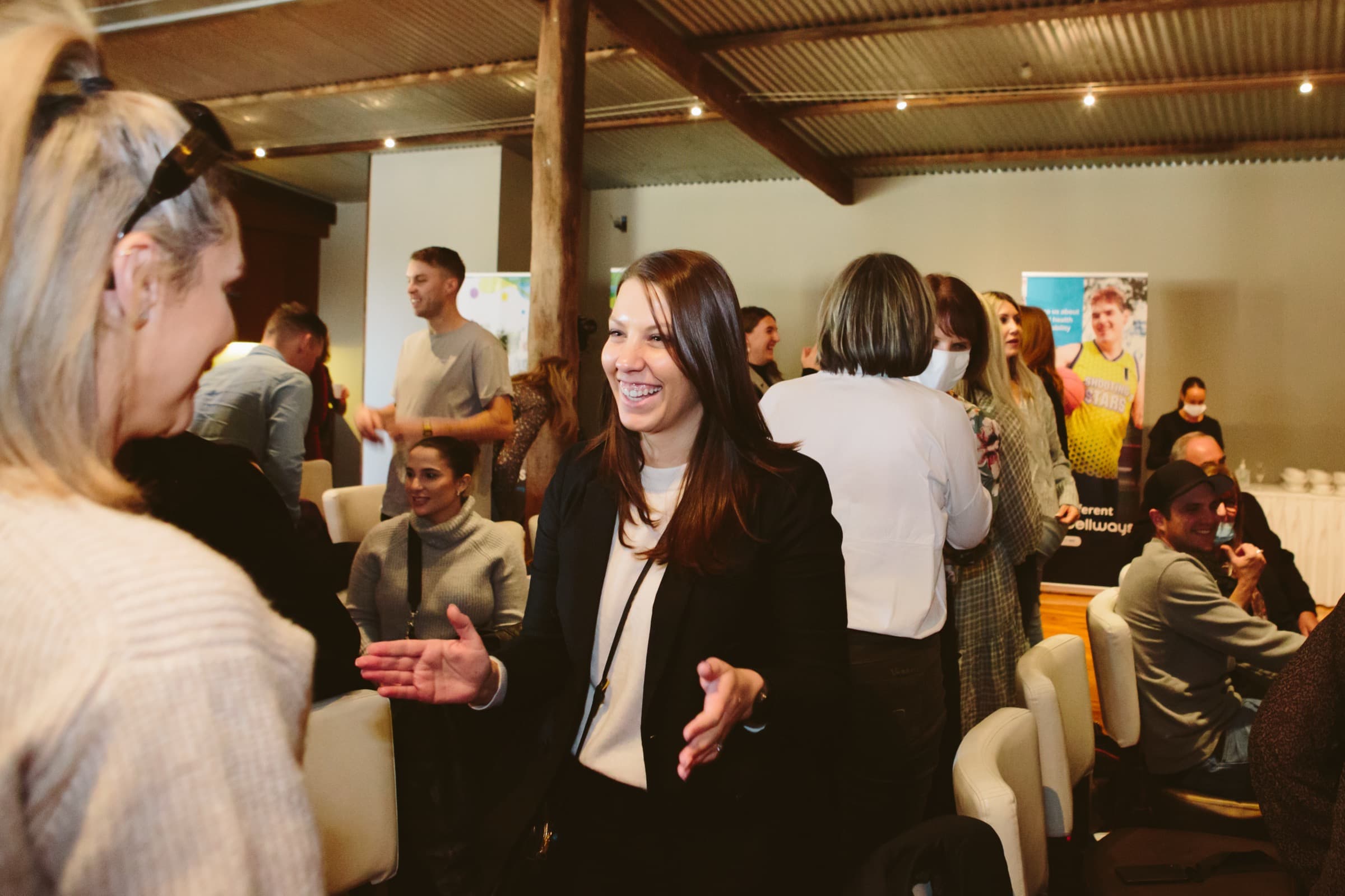 A participant in a blazer laughing mid-conversation during a Better Us Project workshop