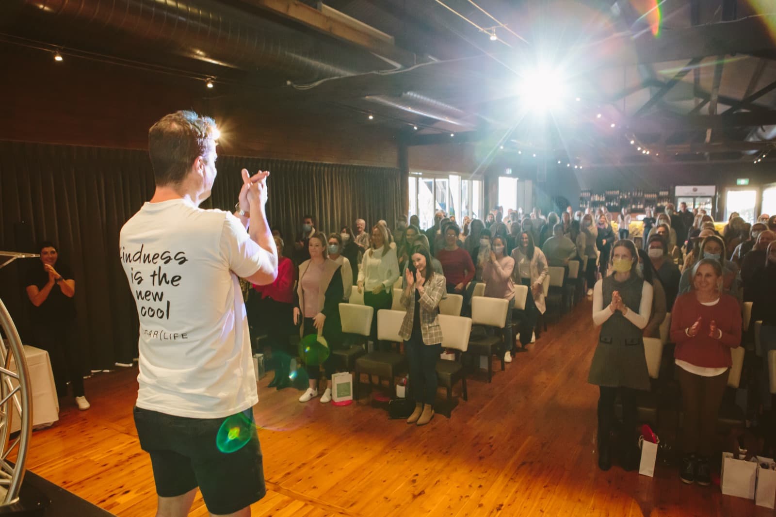A room of leaders on their feet, energised at a Better Us leadership summit